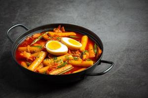 Cheesy Tokbokki korean traditional food on black board background. Lunch dish. photo