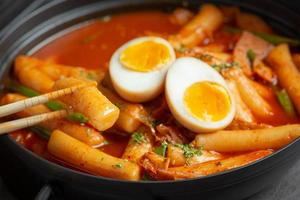 Cheesy Tokbokki korean traditional food on black board background. Lunch dish. photo