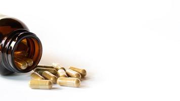 Herbal medicine capsules and glass bottles on a white background photo