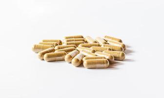 Brown herbal capsules on a white background and hard light photo