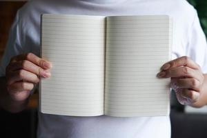 Man holding on a blank notebook with copy space. photo