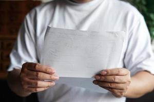 Man hoding hand and read a paper. photo