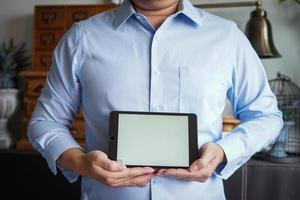 hombre sosteniendo en una tableta dispositivos móviles con pantalla vacía. foto