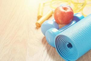 Fitness concept with a blue dumbbells and yoga mat, copy space photo