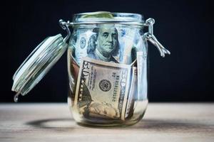 Paper dollar banknotes in glass jar, Money saving concept photo