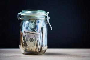 Paper dollar banknotes in glass jar, Money saving concept photo