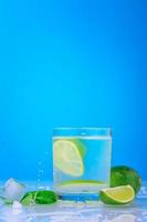 cocktail with lime and fresh mint in glass on a blue background