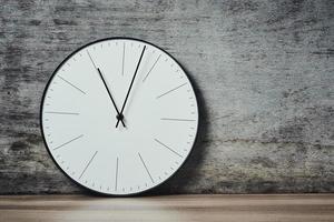 Classic round wall clock on a wooden background with copy space photo