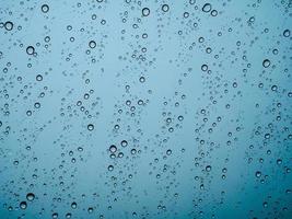 Closeup raindrops on glass car in the rainy season. photo