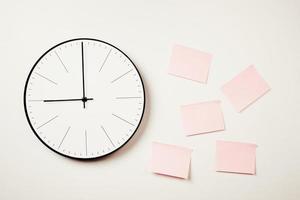 reloj de pared y pegatinas rosas sobre un fondo blanco. maqueta de espacio de trabajo foto