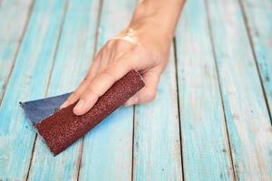 Hands polishing wooden boards with a sandpaper photo