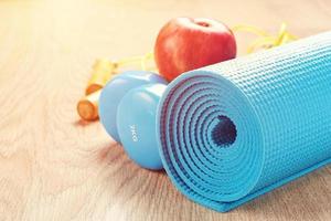 concepto de fitness con pesas azules y colchoneta de yoga foto