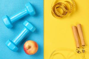 Flat lay, top view minimal background, fitness concept. Sport accessories on a blue and yellow background photo