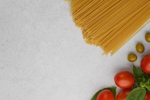 Spaghetti with pasta ingredients on stone background with copy space. photo