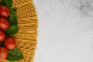 Spaghetti with tomato and basil border. Copy space. photo