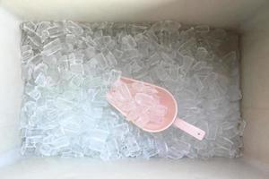 Ice in a container with a scoop. photo