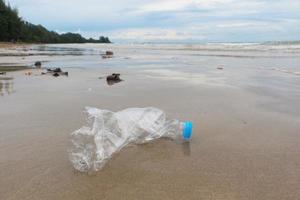 se dejan botellas de plástico en la playa después de que los turistas hayan tomado unas vacaciones. basura en la playa de arena. foto