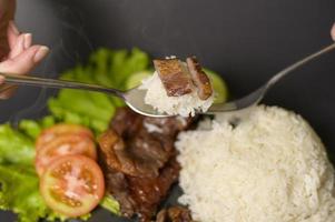 grilled beef with rice on plate over black background studio