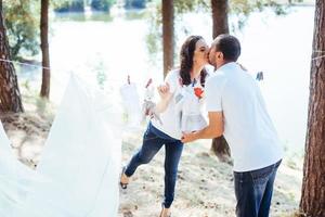 man and woman hanging clothes baby  on the rope outdoors photo