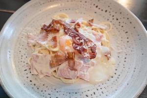Homemade carbonara spaghetti with onsen egg, crispy bacon, parmesan cheese and cream sauce. photo