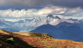 Autumn landscape and snow-capped mountain peaks. View of the mou photo