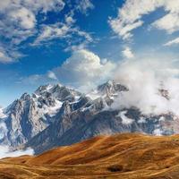 montañas cubiertas de nieve en la niebla. otoño en el lago koruldi foto