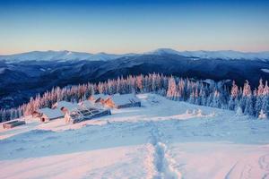 Footprints leading to the chalets in the mountains photo