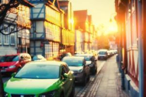 Cars parked along cobblestone way. Natural blurred background. S photo