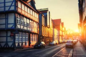 Cars parked along cobblestone way. Natural blurred background. S photo