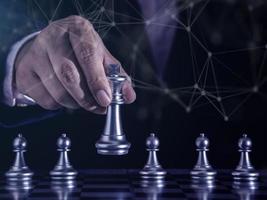 Hand of businessman moving gold king chess figure in competition success with double exposure digital graphic network line connecting diagram business.Strategy, leadership and management ideas concept photo