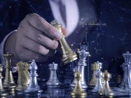 Hand of businessman moving gold king chess figure in competition success with double exposure digital graphic network line connecting diagram business.Strategy, leadership and management ideas concept photo