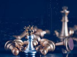 A silver pawn standing crowned in battle chess game on board with gold chess background. To fighting with teamwork to victory, business strategy concept and leader and teamwork concept for success. photo