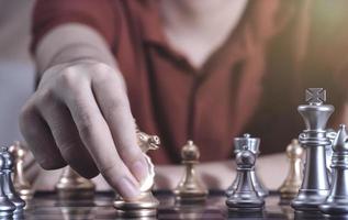 Hand of confident boy moving pawn chess to development in competition success play which new strategy plan, leader and teamwork, network learning tactics and analysis concept. photo