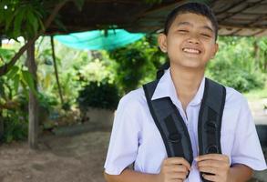 estudiante masculino sonriente feliz de ir a la escuela foto