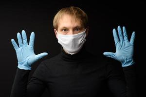 Protection against contagious disease, coronavirus. Man wearing hygienic mask to prevent infection 2019-nCoV. man's panic man puts on protective gloves photo