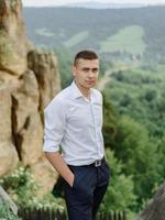 Portrait of a young groom shot in the mountains photo