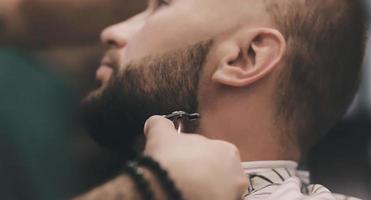 man getting beard haircut by hairdresser photo