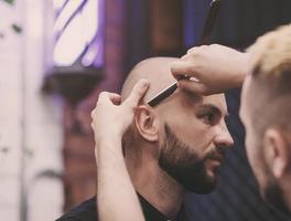 bearded guy sitting in an armchair in barbershop photo