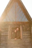 couple in love looks out of the window, wooden house. The concept of buying new housing for young families. photo