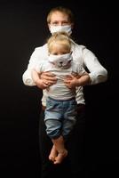 father in a medical mask holds his little daughter. The concept of protecting children during the epidemic of coronavirus photo