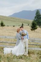 Photoshoot of the bride and groom in the mountains. Boho style wedding photo. photo