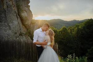 sesión de fotos de una pareja enamorada en las montañas. la niña está vestida como una novia con un vestido de novia.