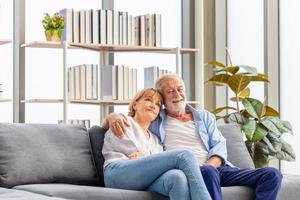 retrato de una feliz pareja de ancianos en la sala de estar, una anciana y un hombre relajándose en un acogedor sofá en casa, conceptos familiares felices foto