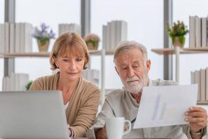 una pareja mayor preocupada revisando sus facturas, una familia anciana jubilada leyendo documentos foto