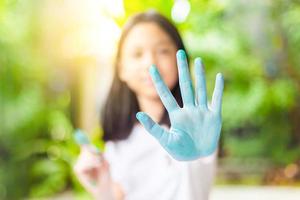 Funny child girl shows hands dirty with paint, Cheerful little cute girl playing and learning with coloring the colors photo