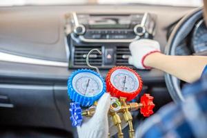 Repairman holding monitor tool to check and fixed car air conditioner system, Technician check car air conditioning system refrigerant recharge, Air Conditioning Repair photo