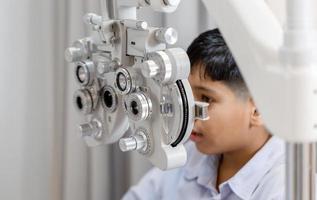 niño haciendo un examen ocular con un optometrista en una tienda óptica, un optometrista haciendo un examen visual para un paciente infantil en una clínica foto