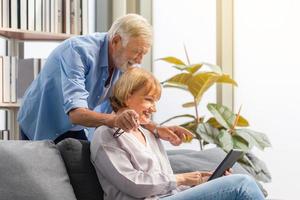 retrato de una feliz pareja de ancianos en la sala de estar, una anciana y un hombre que usa un teléfono inteligente hablando por videollamada en un acogedor sofá en casa, conceptos familiares felices