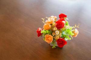 ramo de hermosas flores en un jarrón moderno sobre una mesa de madera para la decoración del hogar foto