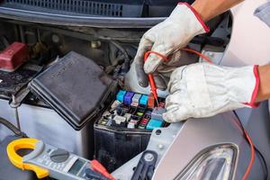 mecánico de automóviles que trabaja en el relé de verificación del motor del automóvil y el fusible en el taller mecánico, servicio de reparación y mantenimiento foto